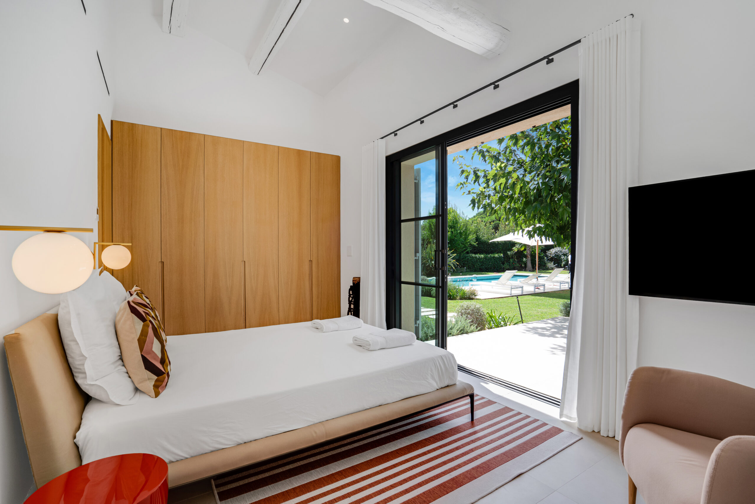 Contemporary bedroom with light wood panelling at Villa Charlotte