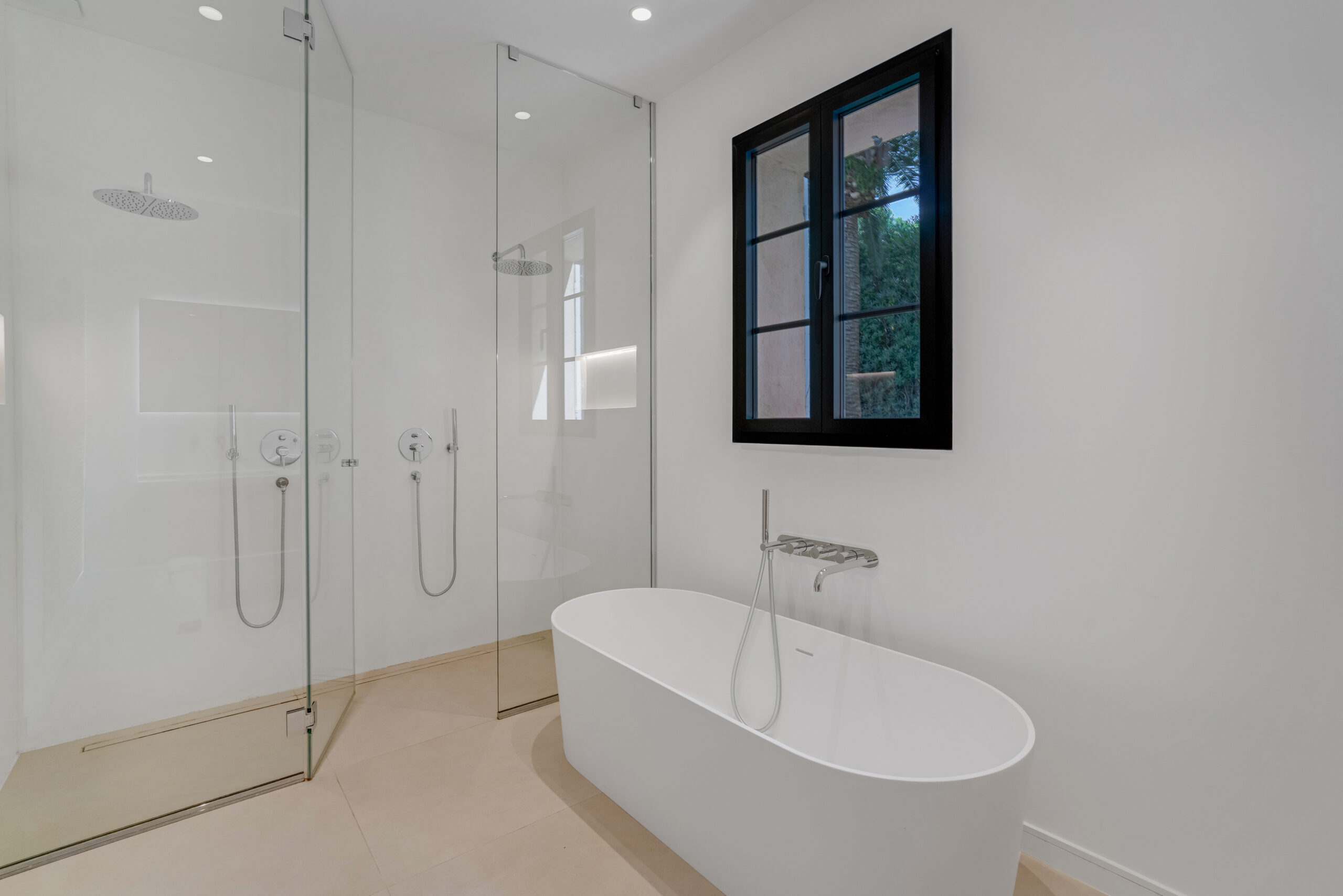 Bathroom with freestanding bathtub and glass shower at Villa Charlotte
