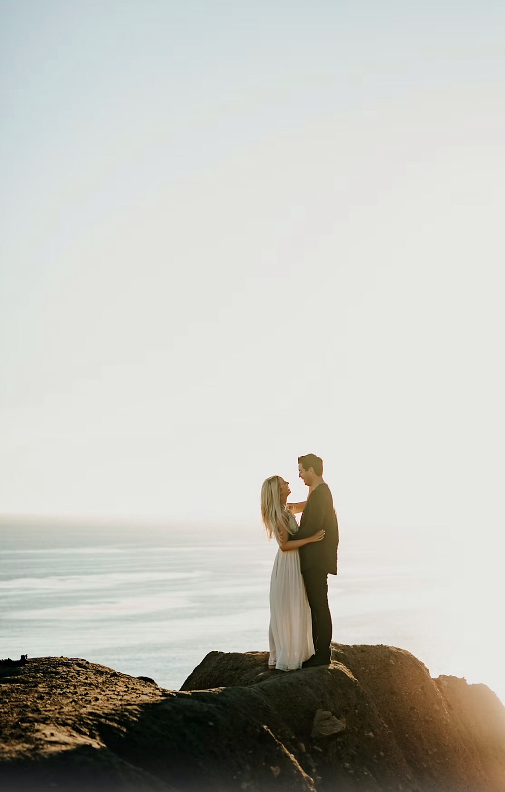 A couple embracing on a clifftop above the Mediterranean in the golden evening light, French Riviera A couple embracing on a clifftop above the Mediterranean in the golden evening light, French Riviera