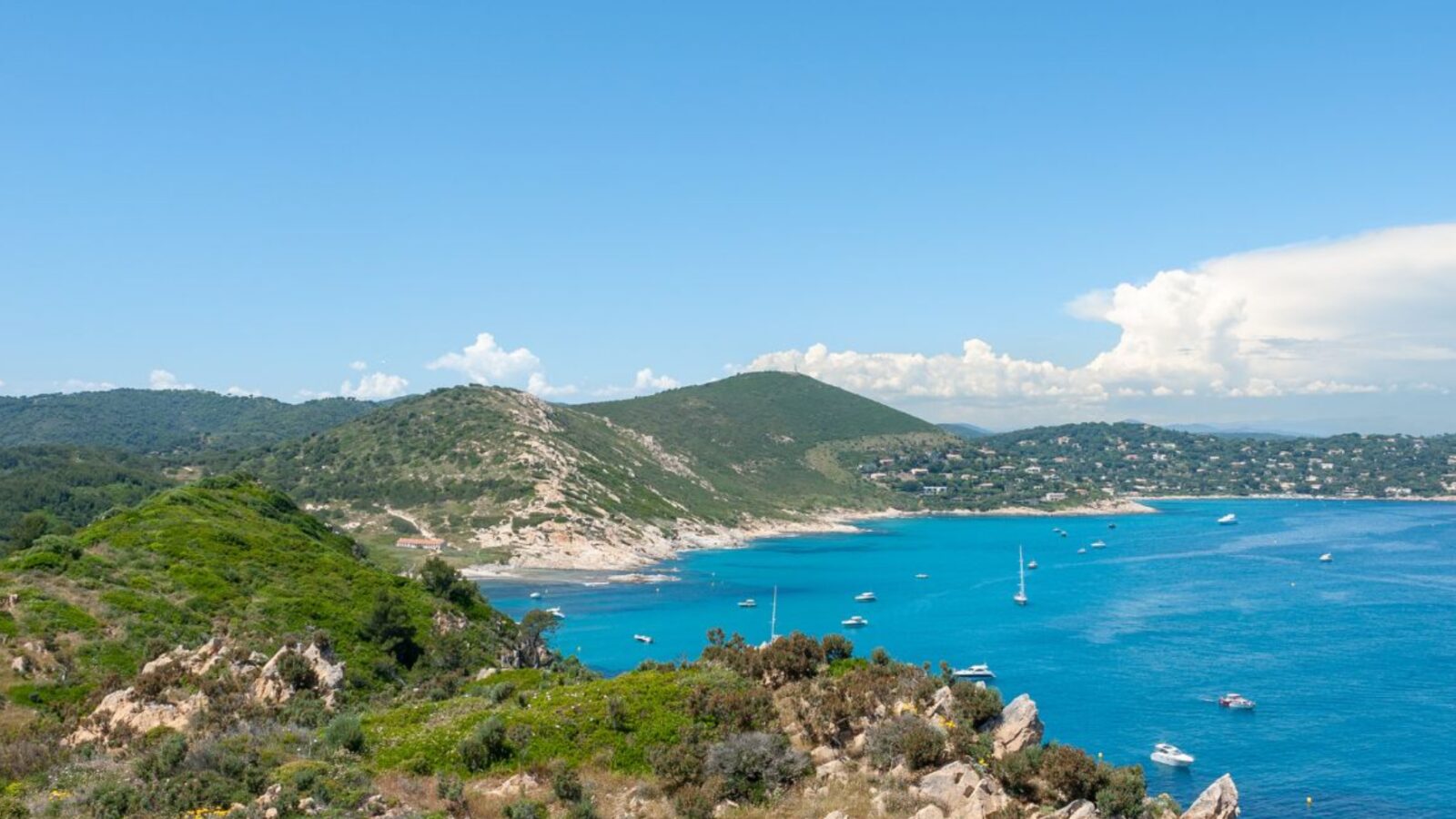 Turquoise bay with sailboats at anchor below the coastal hills near Saint-Tropez Turquoise bay with sailboats at anchor below the coastal hills near Saint-Tropez