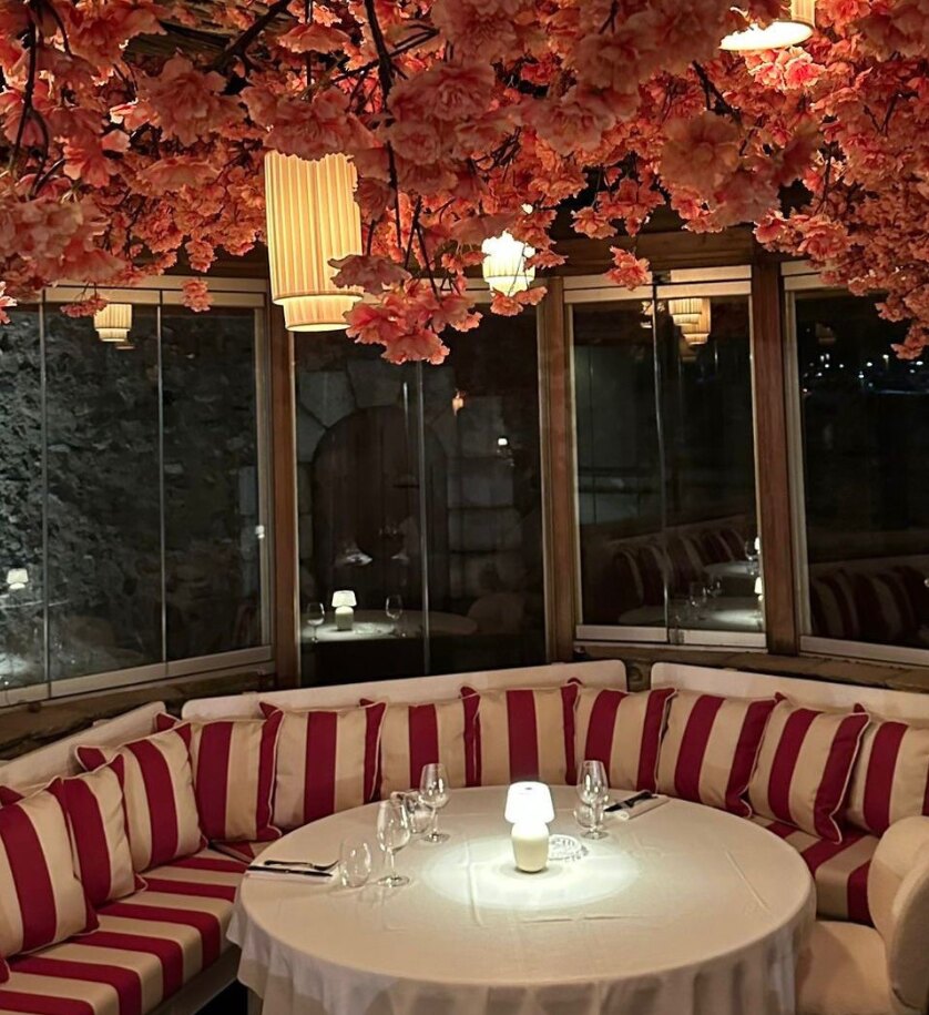 La table ronde et la banquette rayée rouge et blanche de Cherry, sous les fleurs de cerisier