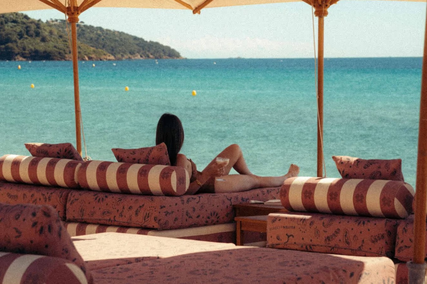 Matelas roses et coussins rayés sous les parasols de Cybèle, face à la mer turquoise de Pampelonne
