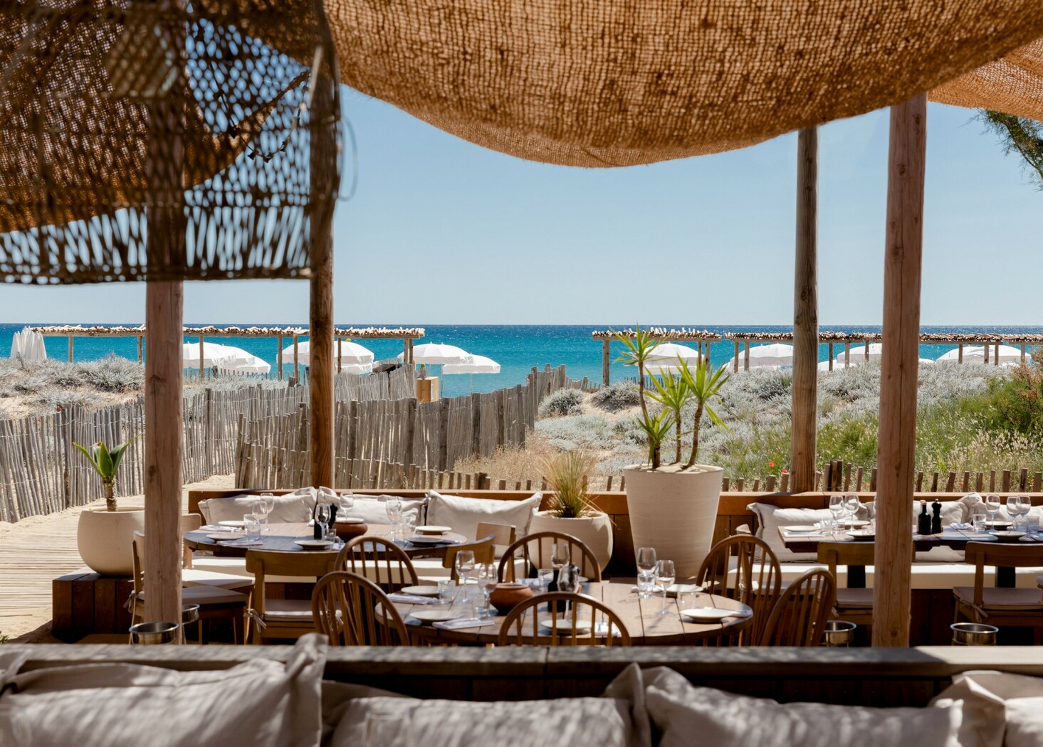 Tables dressées sous les toiles blanches d’Indie Beach, face à la mer à Pampelonne