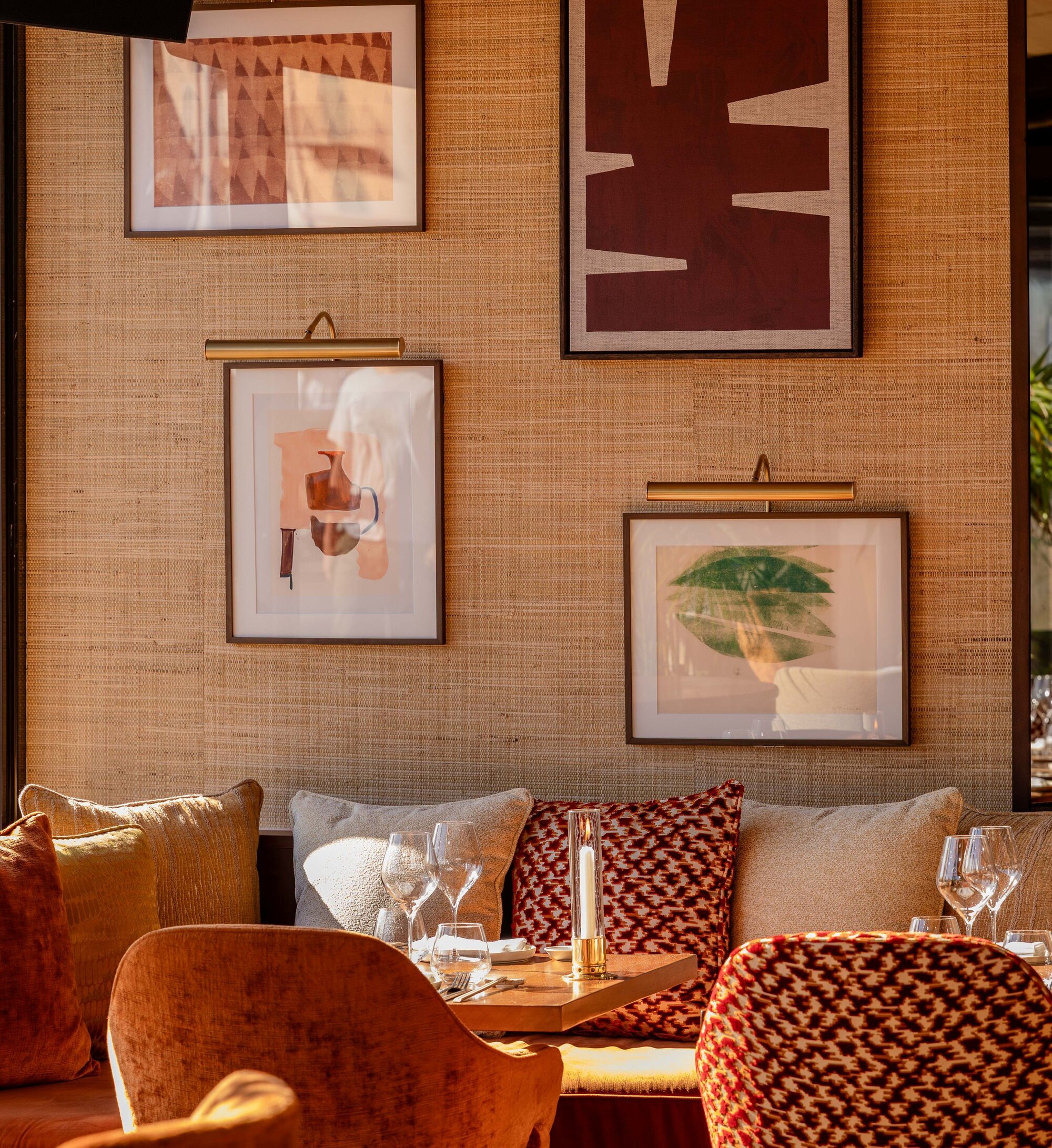 La salle chaleureuse de NAŌ sur le port de Saint-Tropez, banquettes et œuvres d’art